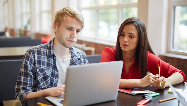 Two students studying together on a laptop
